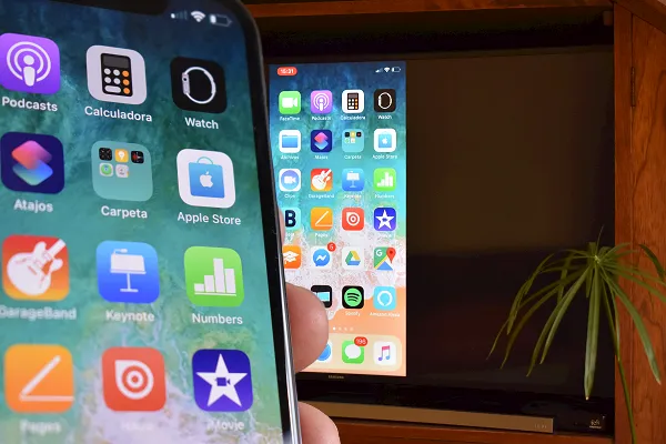 Tela de um iPhone refletida em uma TV conectada a um Chromecast.