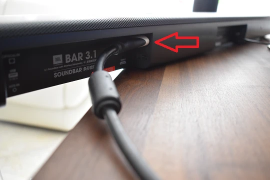 a parte posterior de uma barra de som com o cabo HDMI ligado à porta HDMI ARC.