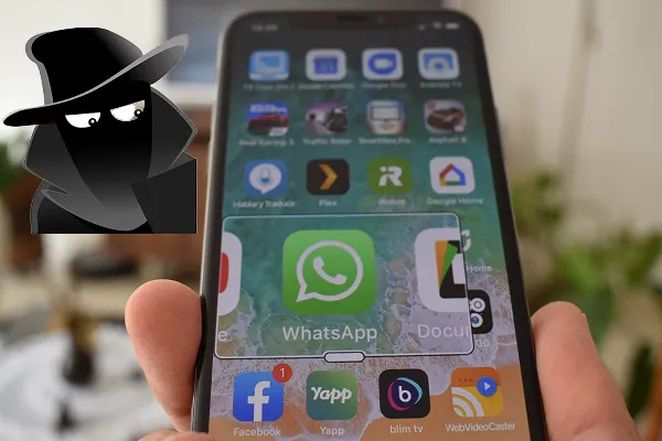 Imagem de homem mascarado, olhando para a tela de um smartphone com o ícone do WhatsApp em primeiro plano
